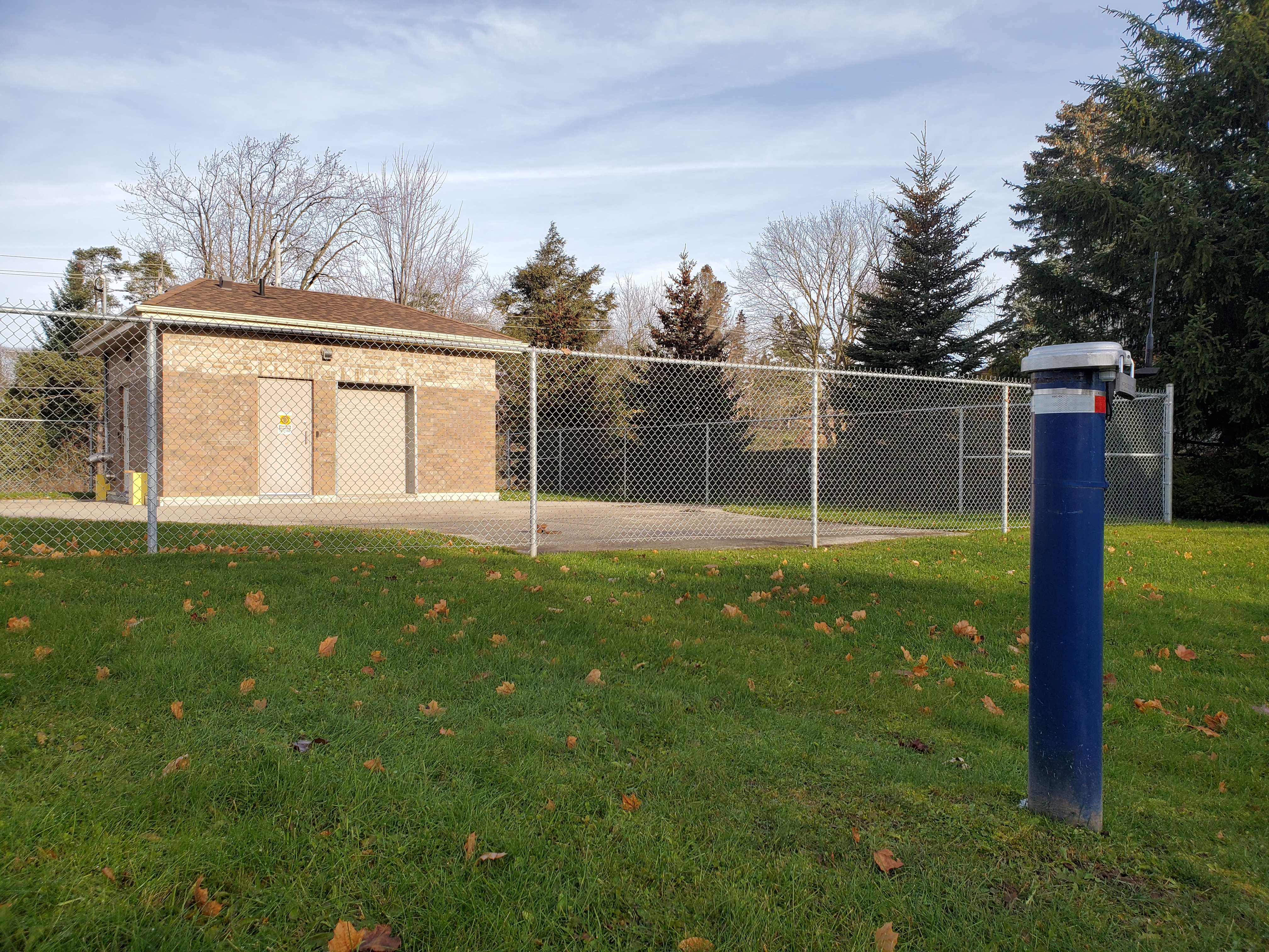 Pump house with supply well inside and monitoring well in front of pump house