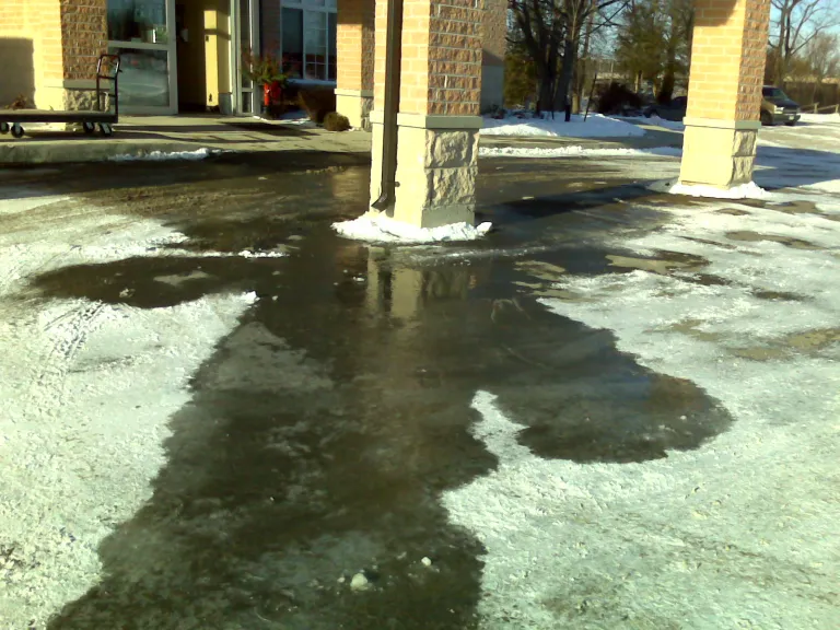 Downspout pooling onto paved area requiring more salt to deal with ice