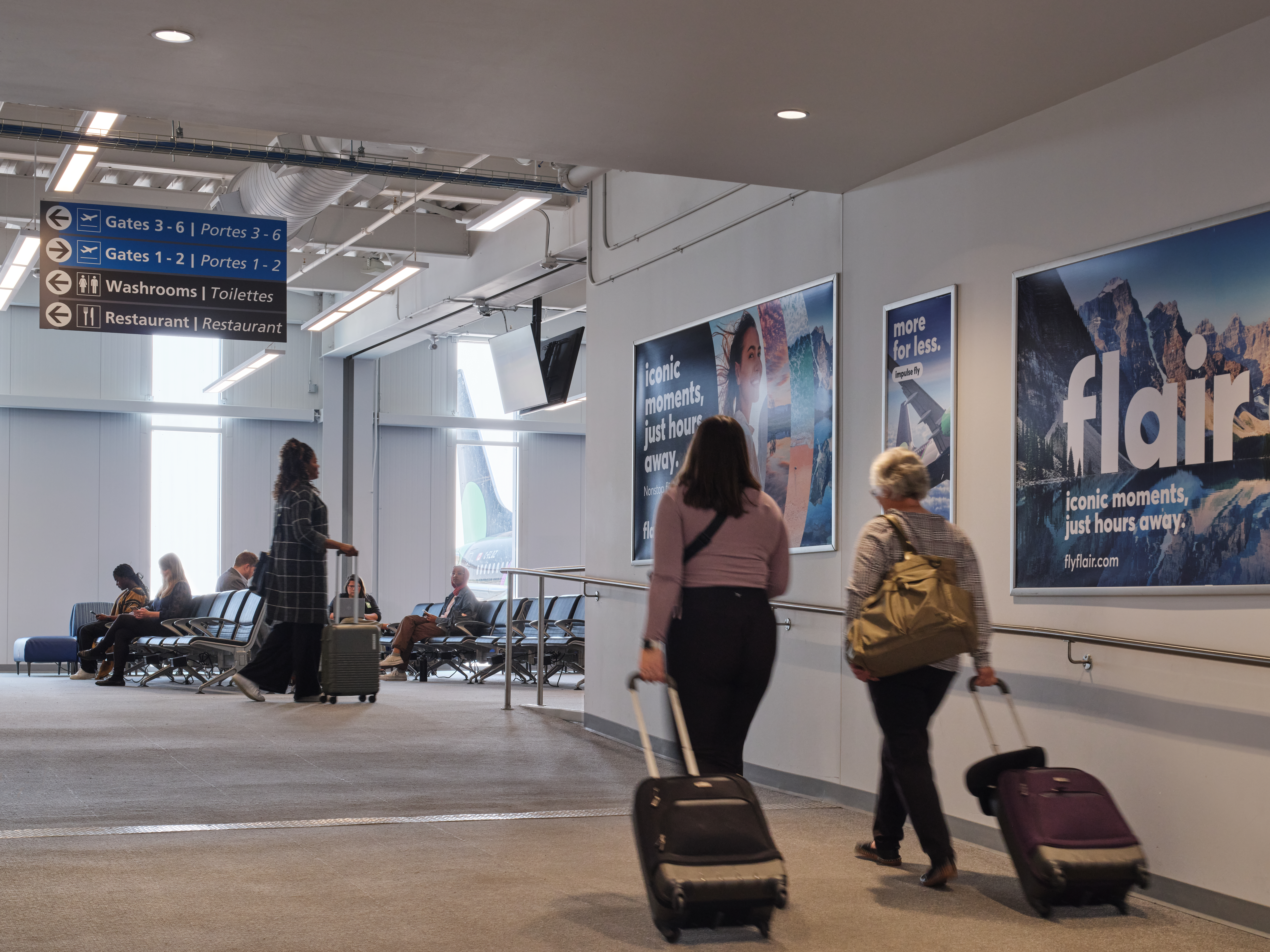 Passengers walking in the departures lounge with their luggage