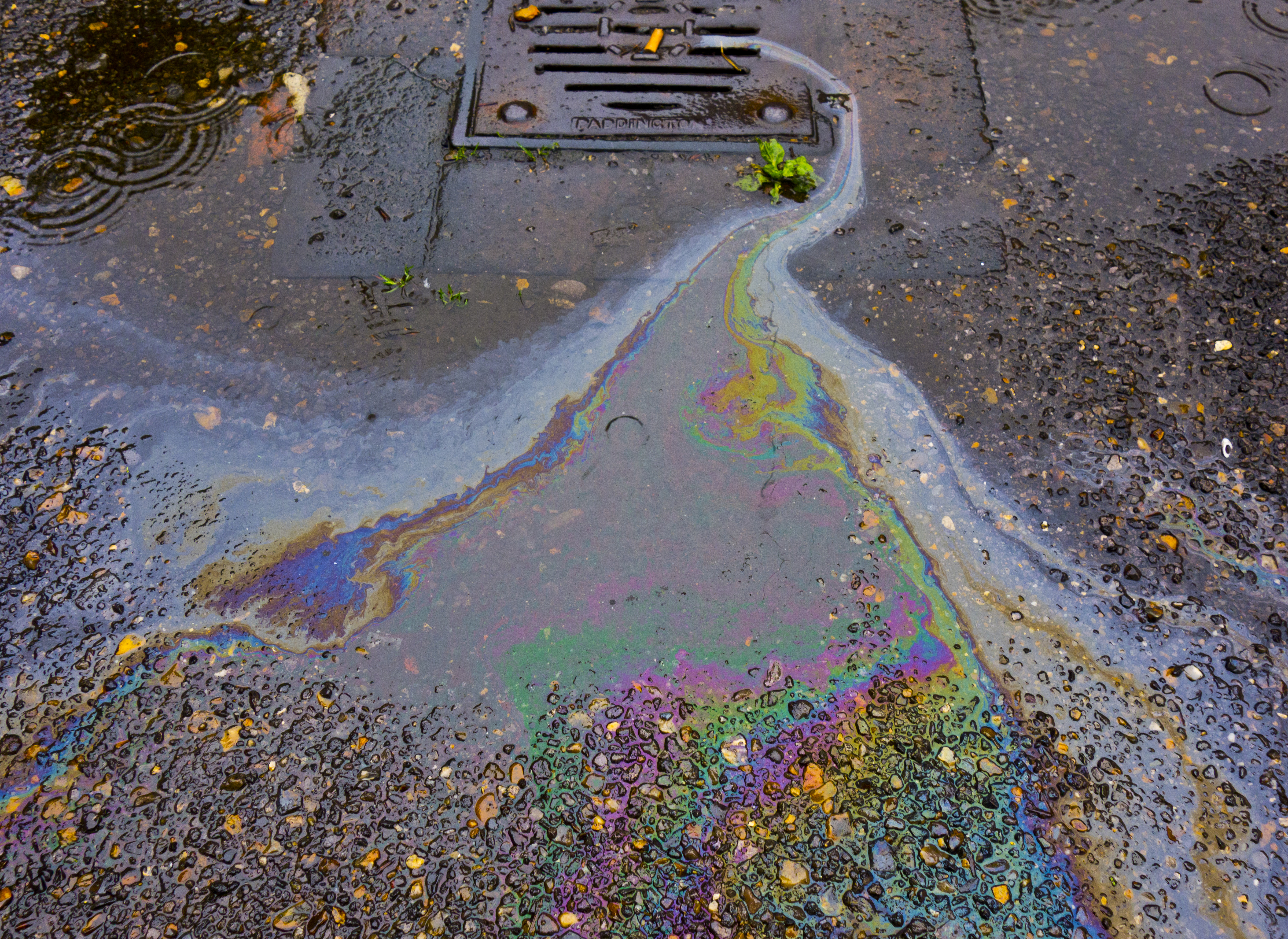 Chemical spill draining into catch basin or storm drain.