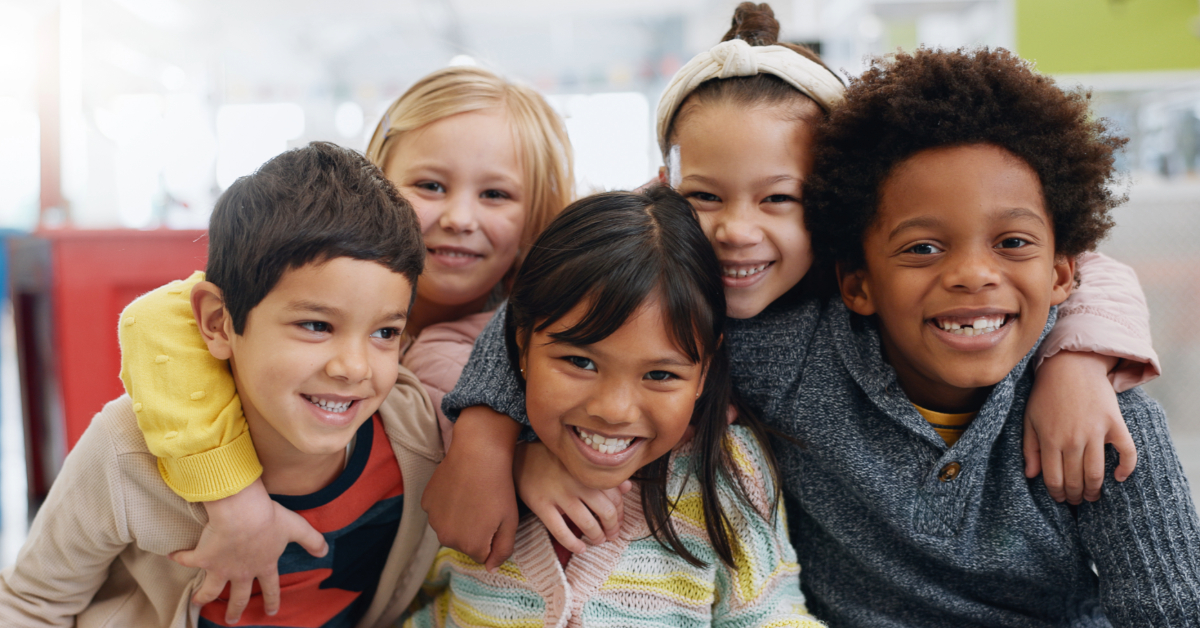 A group of children smile to the camera.