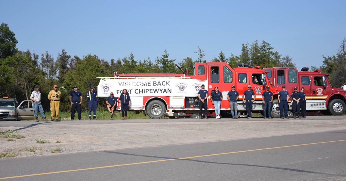 fort chipewyan fire department stands with a welcome home banner