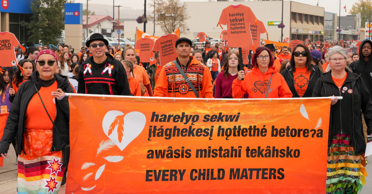 Marchers hold up a "Every Child Matters" banner during the community walk on National Day for Truth and Reconciliation, on Sept. 28, 2023 in downtown Fort McMurray, Alta.