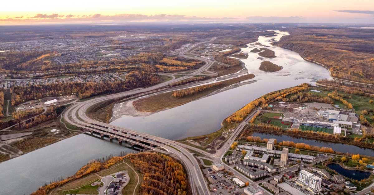 Aerial view of downtown Fort McMurray and the intersection of the Athabasca and Clearwater rivers as surrounding trees turn to fall colours.