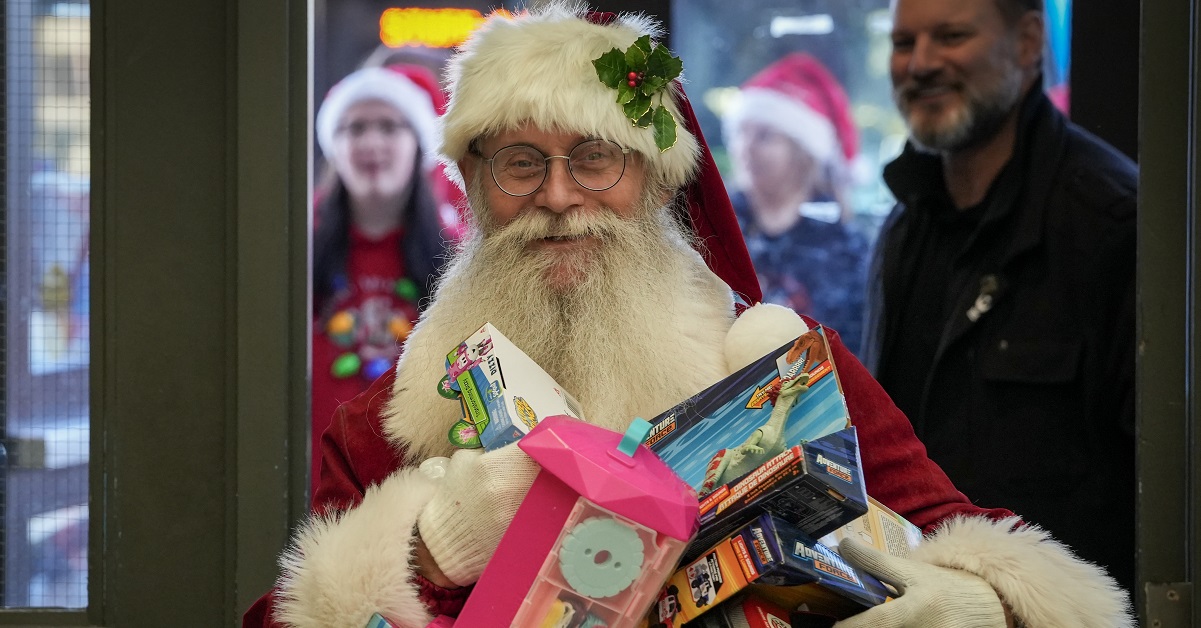 Santa Claus unloads toys for Santas Anonymous at Father Mercredi High School