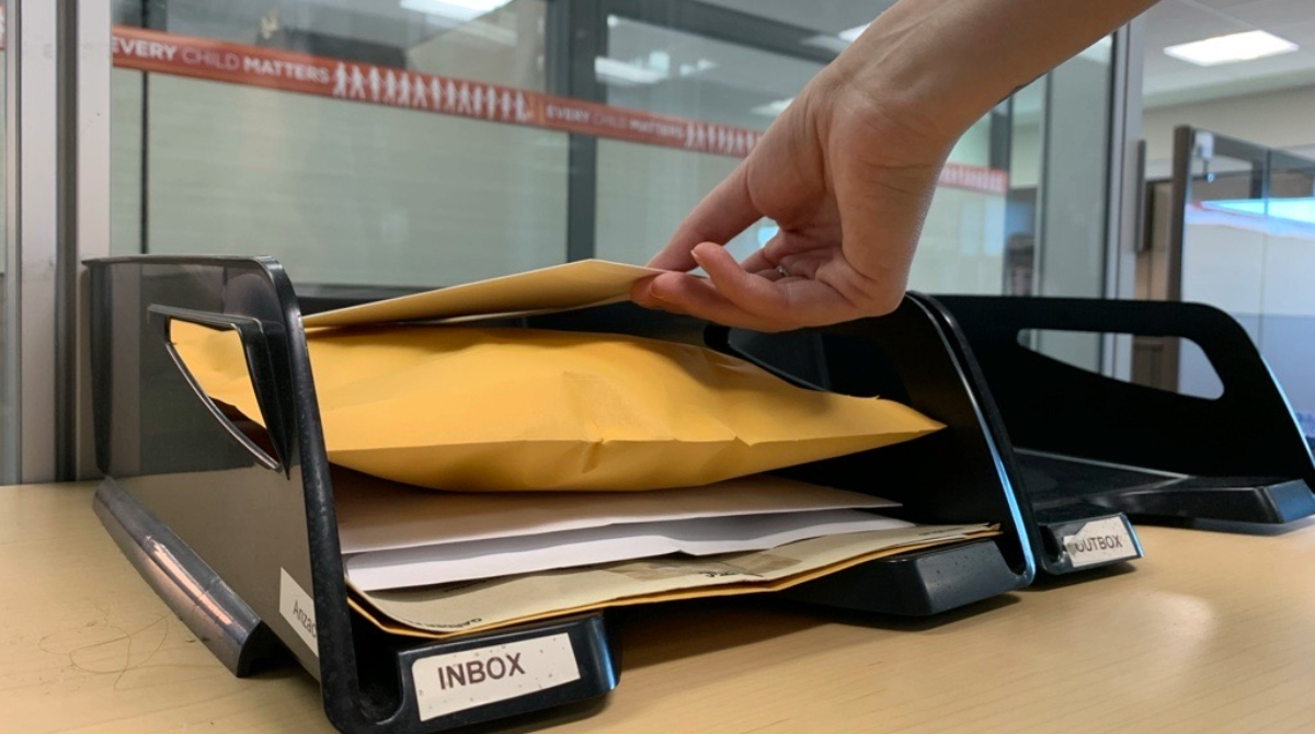 hand picking up mail from intray
