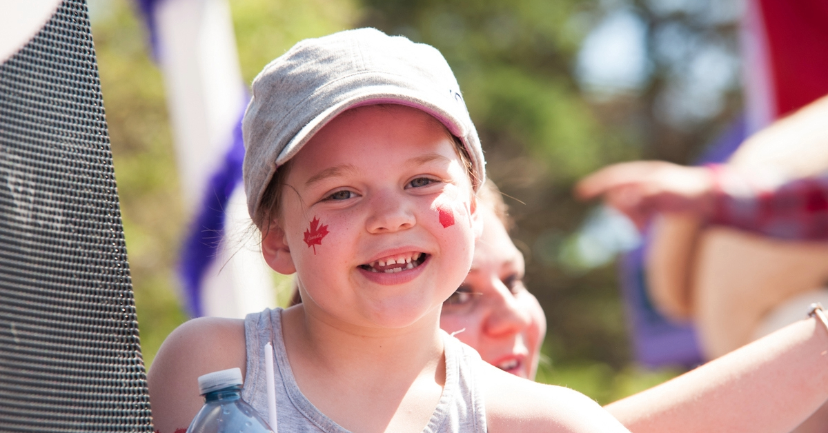A young resident smiles during the Canada Day Parade on Franklin Ave.