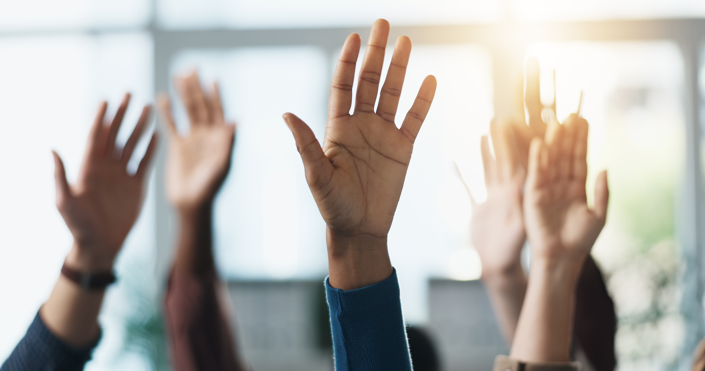 This is a photo of hands raised in the air to ask questions. 