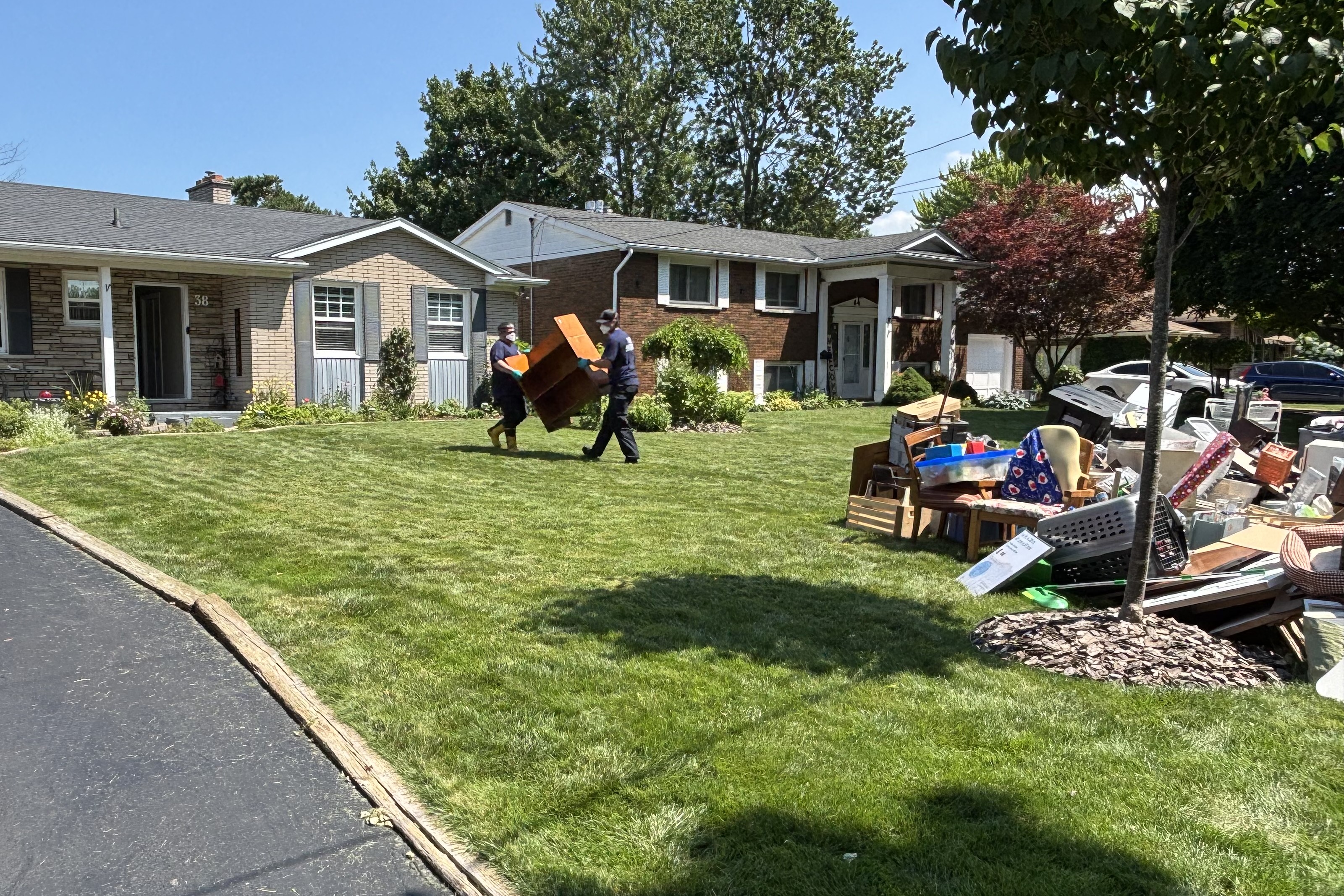 St. Catharines firefighters remove flood-damaged items from a home.