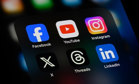 person holding mobile device with social media app icons on their screen