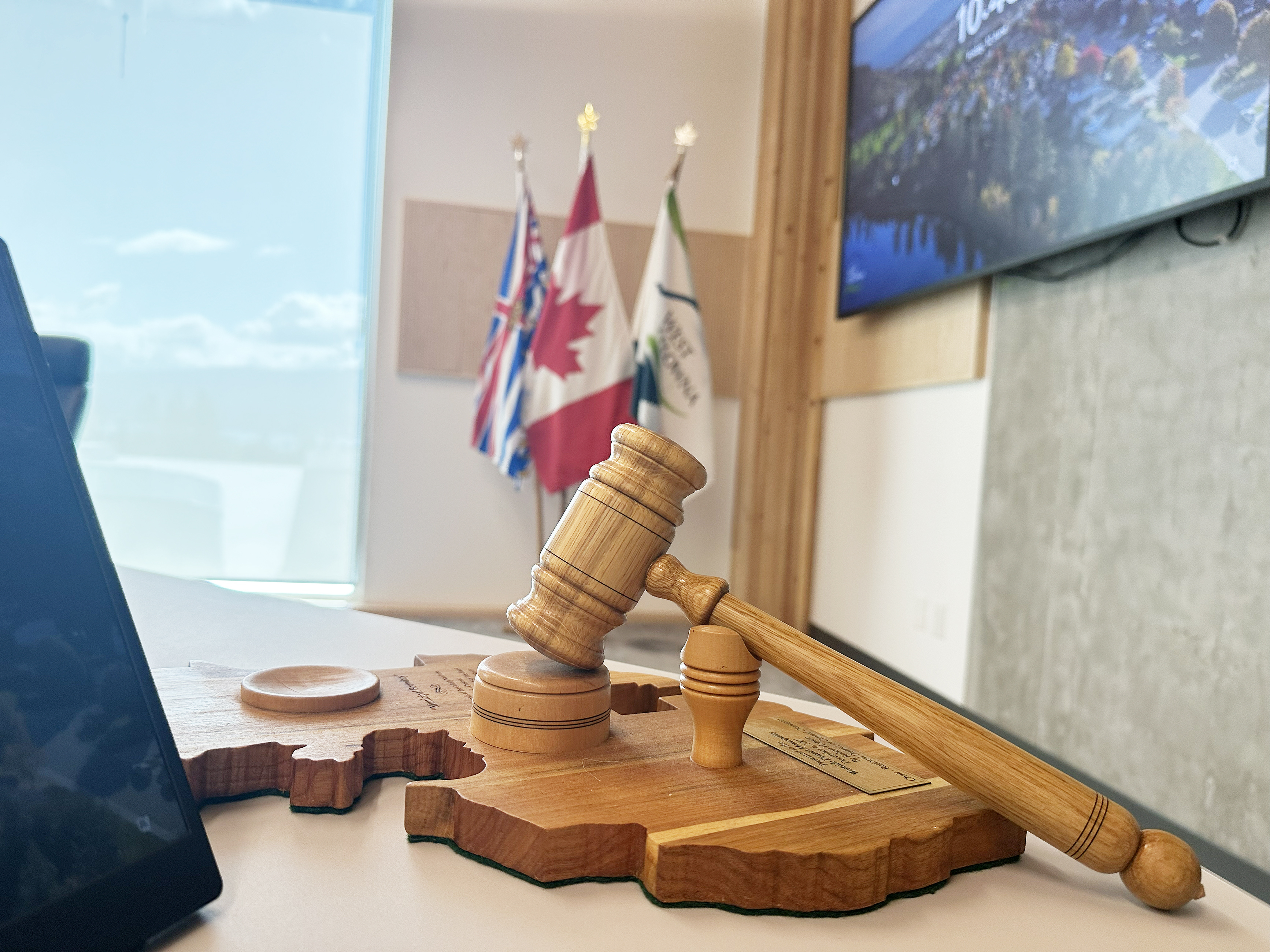 A gavel sits on mayor's desk with Canada, BC and West Kelowna flags in background