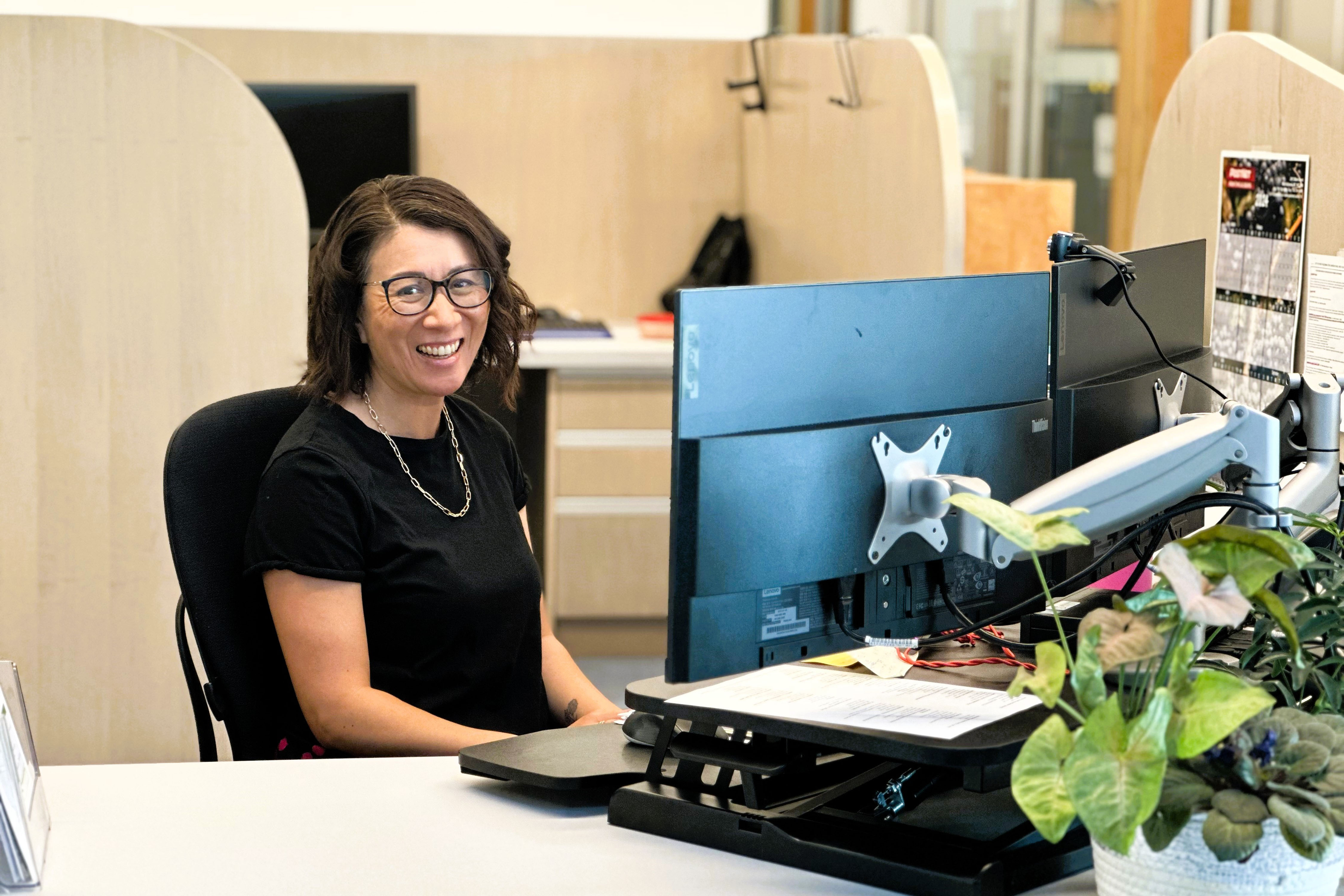 A customer service representative smiles as they welcome the public.