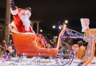 Santa Claus in sleigh with arms raised