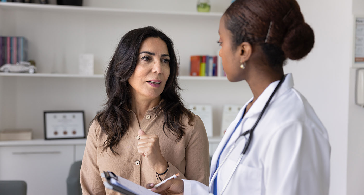 Older female patient speaking with female physician