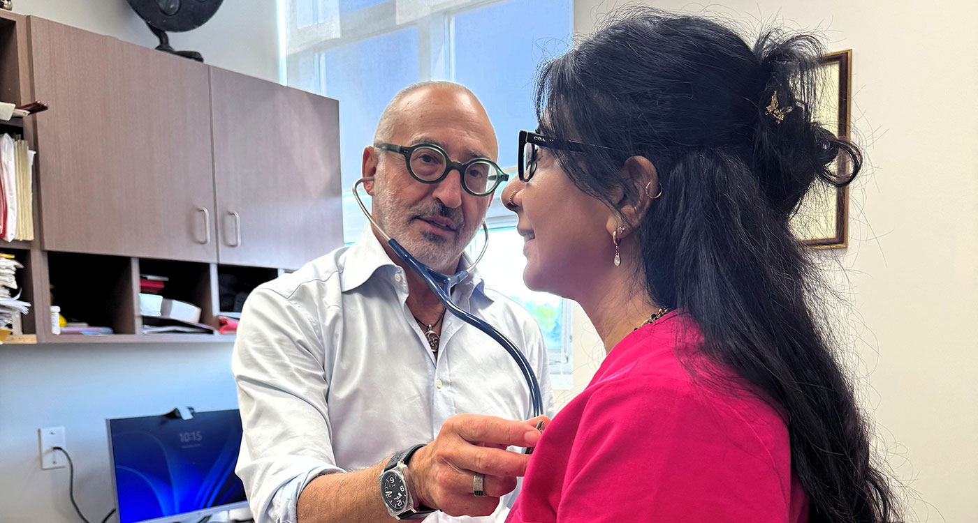 (l-r): Dr. Shane Teper uses a stethoscope on a patient